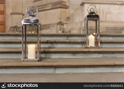 Illuminated Candles in Glass and Metal Lanterns on Stone Steps