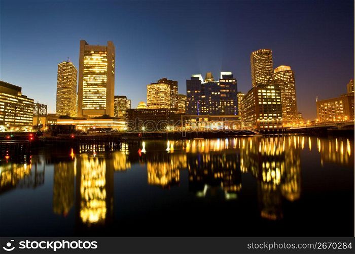 Illuminated cityscape by river