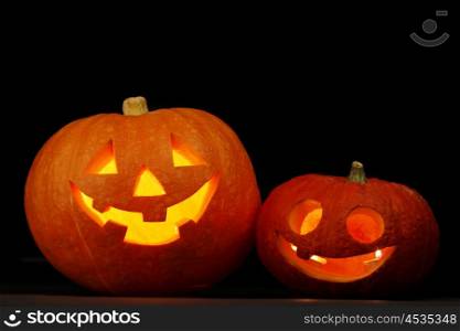Illuminated cute glowing halloween pumpkin on black background