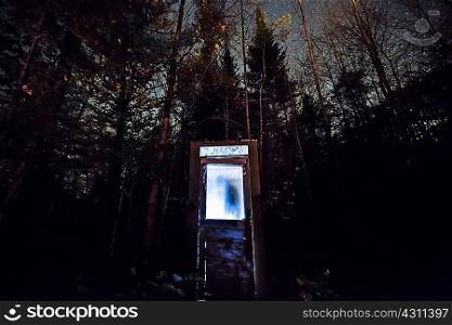 Illuminated door in forest at night