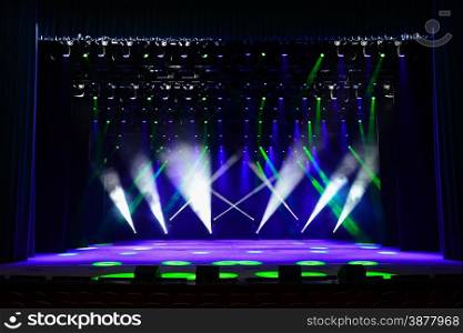 Illuminated empty theater stage with fog and rays of light
