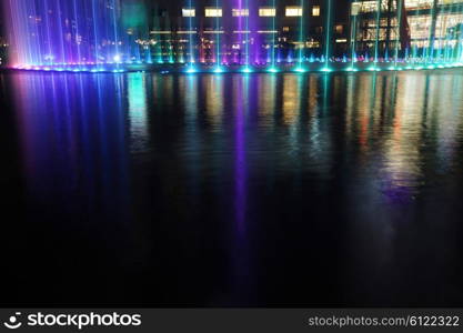 Illuminated fountain at night in modern city skyline, Kuala Lumpur