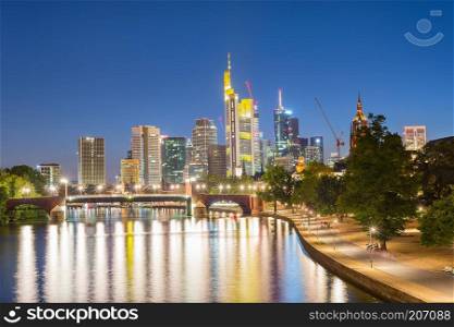 Illuminated Frankfurt skyline with bridge by embankment, Germany, Europe