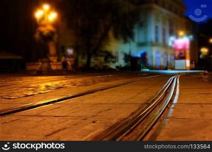 Illuminated street of old european town at night. Tilt-shift effect