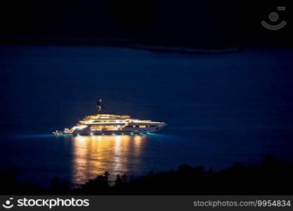 Illuminated superyacht on the sea night view, summer leisure, Hvar island, Croatia 