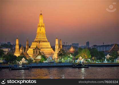 Illuminated Temple of Dawn or Wat Arun at sunset. Bangkok, Thailand