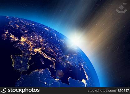Illustration of the sunrise over Planet Earth, European city lights visible. Some elements of the image furnished by NASA.