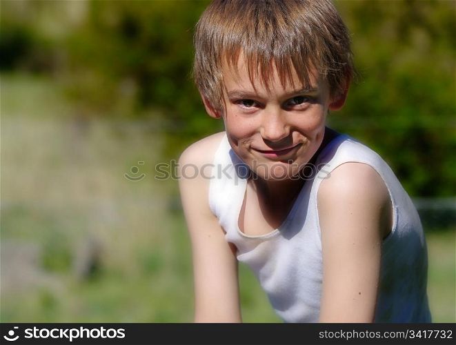 image of a boy in a singlet looking at the camera. boy looking at camera