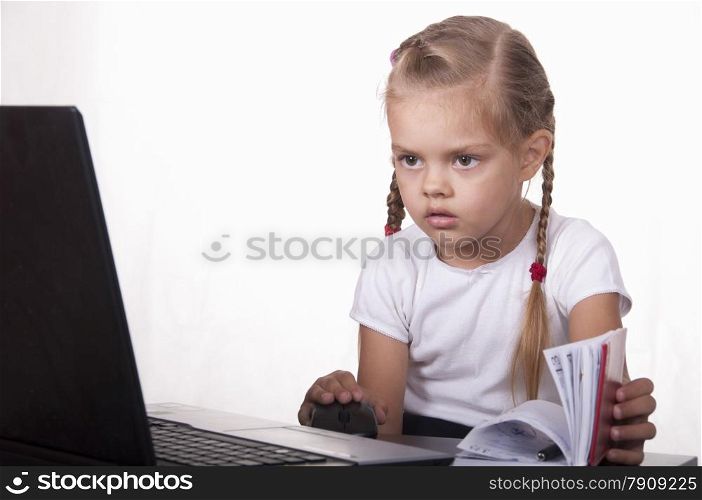Image of a business girl. girl sitting at table. On table is a laptop, girl it works. girl joyfully looking into laptop other hand opens Notepad