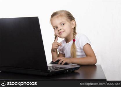 Image of a business girl. The girl sitting at the table. On the table is a laptop, girl it works. The girl was distracted from work and with a smile she looked right.