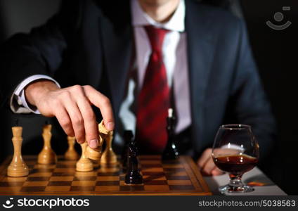 Image of a businessman in dark suit playing chess