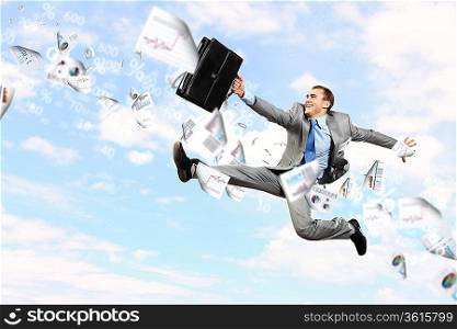 Image of a businessman jumping high against blue sky background
