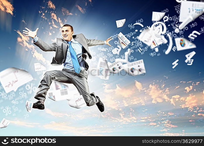 Image of a businessman jumping high against blue sky background