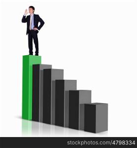 Image of a businessman standing on the top of financial charts