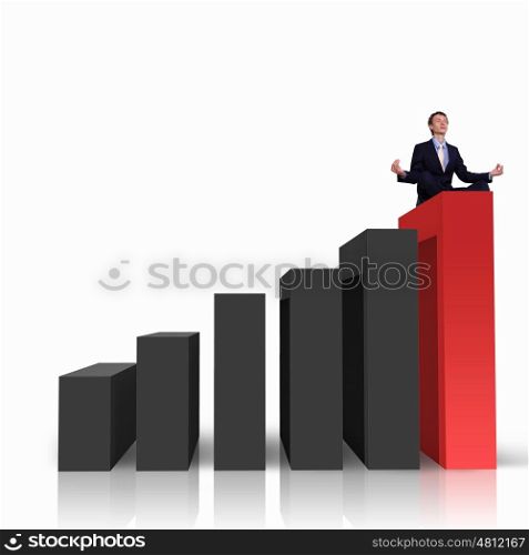 Image of a businessman standing on the top of financial charts