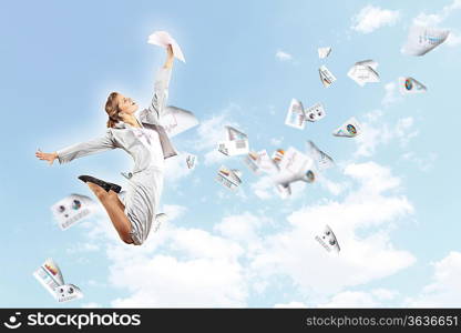 Image of a businesswoman jumping high against blue sky background