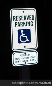 Image of a disabled parking sign at night with penalty for misuse