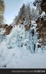 Image of a frozen waterfall in deep rock canyon in Carpathian mountains near Manyava village