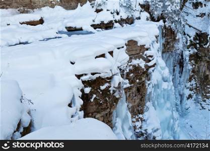 Image of a frozen waterfall in deep rock canyon. View from top