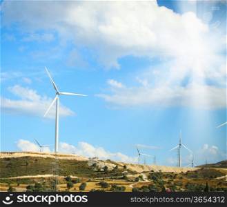 Image of a large windmill on the hill sunny day
