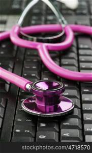image of a pink stethoscope on a black keyboard