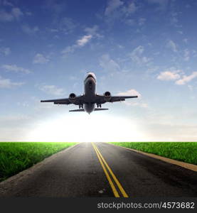 Image of a white passenger plane and blue sky with clouds