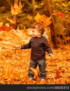 Image of adorable child enjoy autumn nature, pretty small male walking in the park, cheerful infant having fun in fall forest, happy boy spending time in beautiful fall woods, autumnal holiday