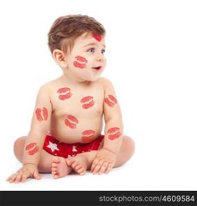Image of adorable child with red kisses on the skin, happy baby boy sitting down in the studio and isolated on white background, little love angel, romantic holiday, Valentines day concept