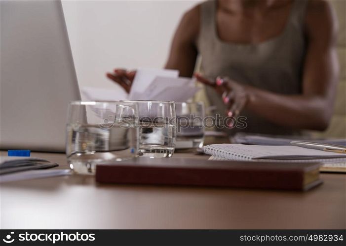 Image of african female hands leafing through book or notepad during discussion at meeting