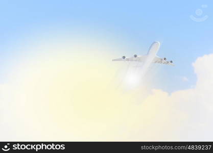 Image of airplane in sky. Image of flying airplane in clear sky with sun at background