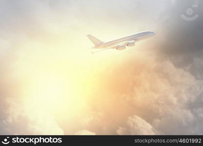 Image of airplane in sky. Image of flying airplane in sky with clouds at background