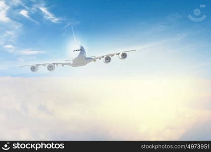 Image of airplane in sky. Image of flying airplane in sky with clouds at background