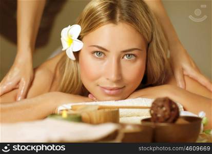 Image of beautiful woman laying down and relaxed on massage table, pretty blond girl enjoying dayspa, alternative medicine, masseur doing antistress massaging for cute patient, luxury spa salon