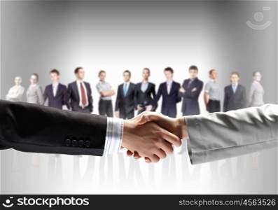 image of business handshake. business handshake against white background and standing businesspeople