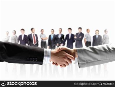 image of business handshake. business handshake against white background and standing businesspeople
