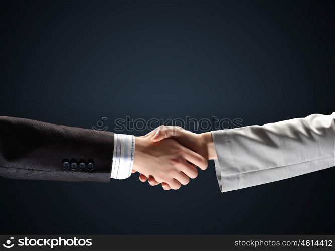 image of business handshake. image of business handshake against black background