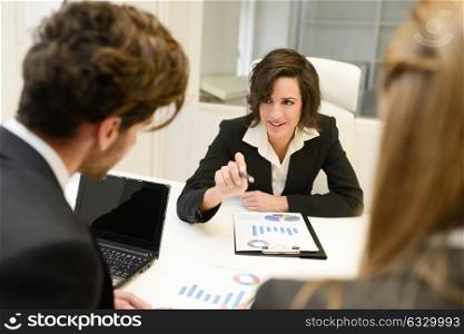 Image of business partners discussing documents and ideas at meeting. Woman leader wearing blazer