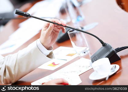 Image of businessman&acute;s hands holding microphone at conference