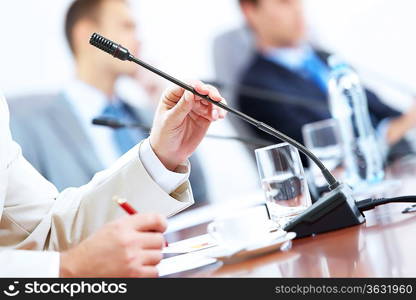 Image of businessman&acute;s hands holding microphone at conference