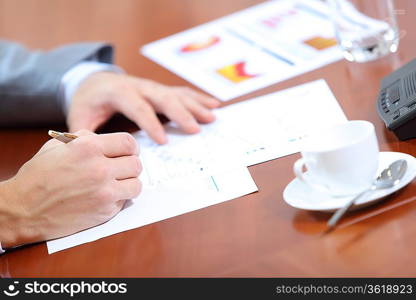 Image of businessman&acute;s hands signing documents at meeting