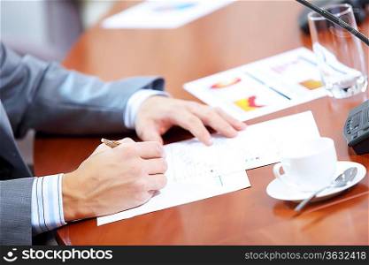 Image of businessman&acute;s hands signing documents at meeting