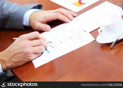 Image of businessman&acute;s hands signing documents at meeting