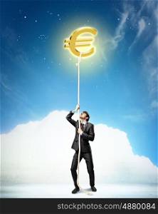 Image of businessman climbing rope. Image of businessman climbing rope attached to euro sign