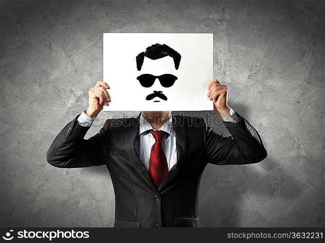 Image of businessman holding drawing against face. Conceptual photo