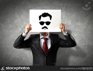 Image of businessman holding drawing against face. Conceptual photo