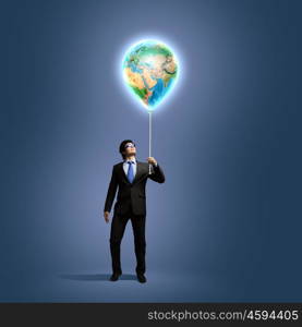 Image of businessman in goggles holding globe. Protect planet. Elements of this image are furnished by NASA