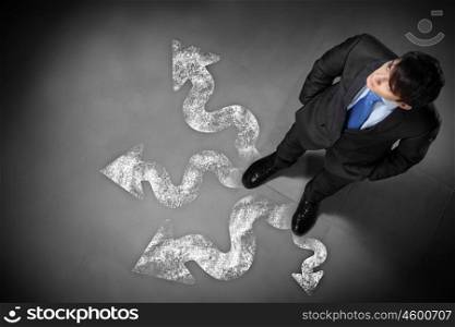 Image of businessman top view. Top view of businessman standing against directions background