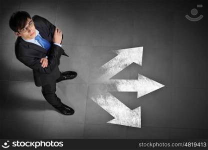 Image of businessman top view. Top view of businessman standing against directions background