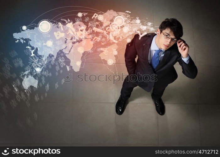 Image of businessman top view. Top view of young businessman making decision against global network back