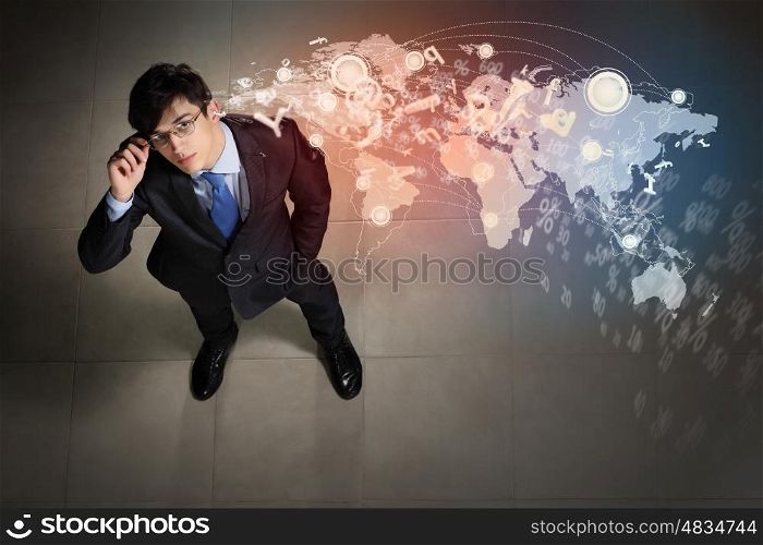 Image of businessman top view. Top view of young businessman making decision against global network back